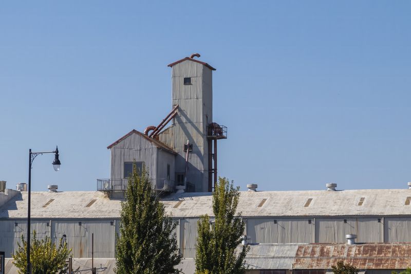 Exterior of an industrial warehouse with a metal roof (placeholder stock photo)