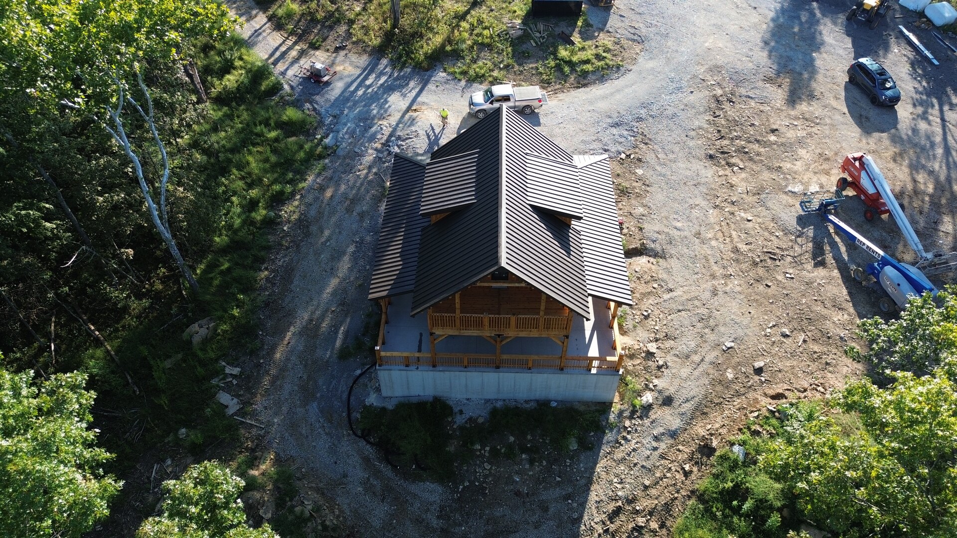 Aerial front view of Cabin One with brown snap-lock metal roofing in Pleasureville, Kentucky.
