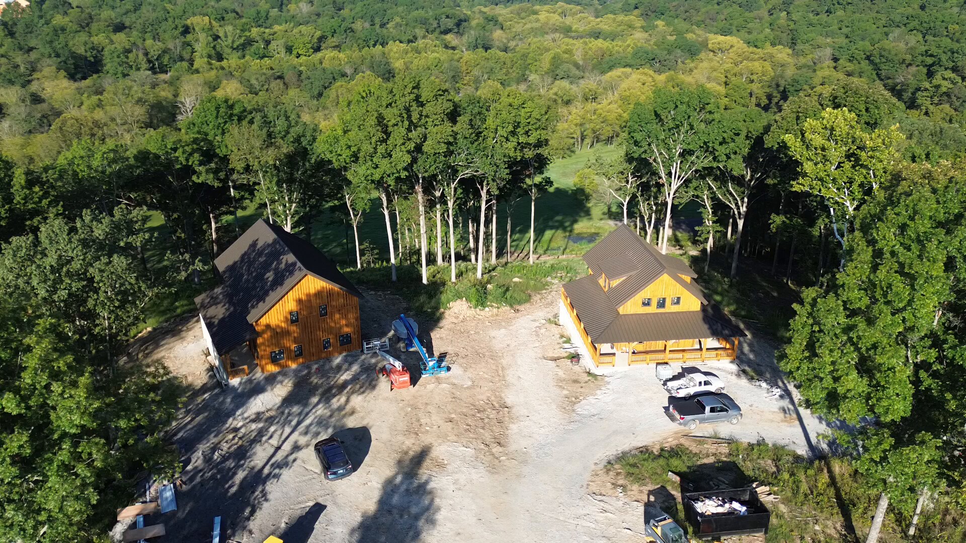 Aerial overview of two cabins with brown snap-lock metal roofs in Pleasureville, Kentucky.