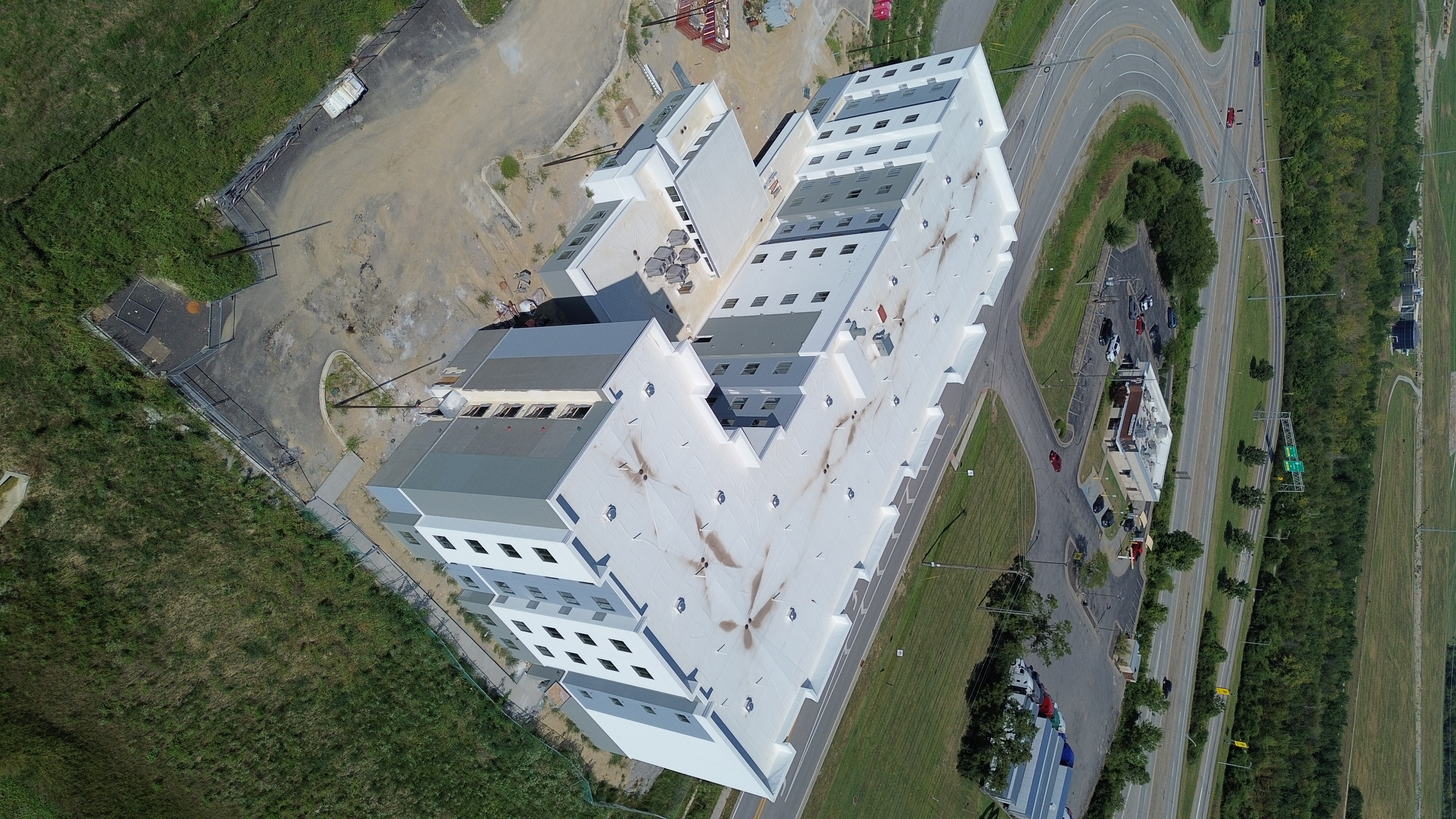 Aerial view of a multi-story hotel's white low-slope roof and building.