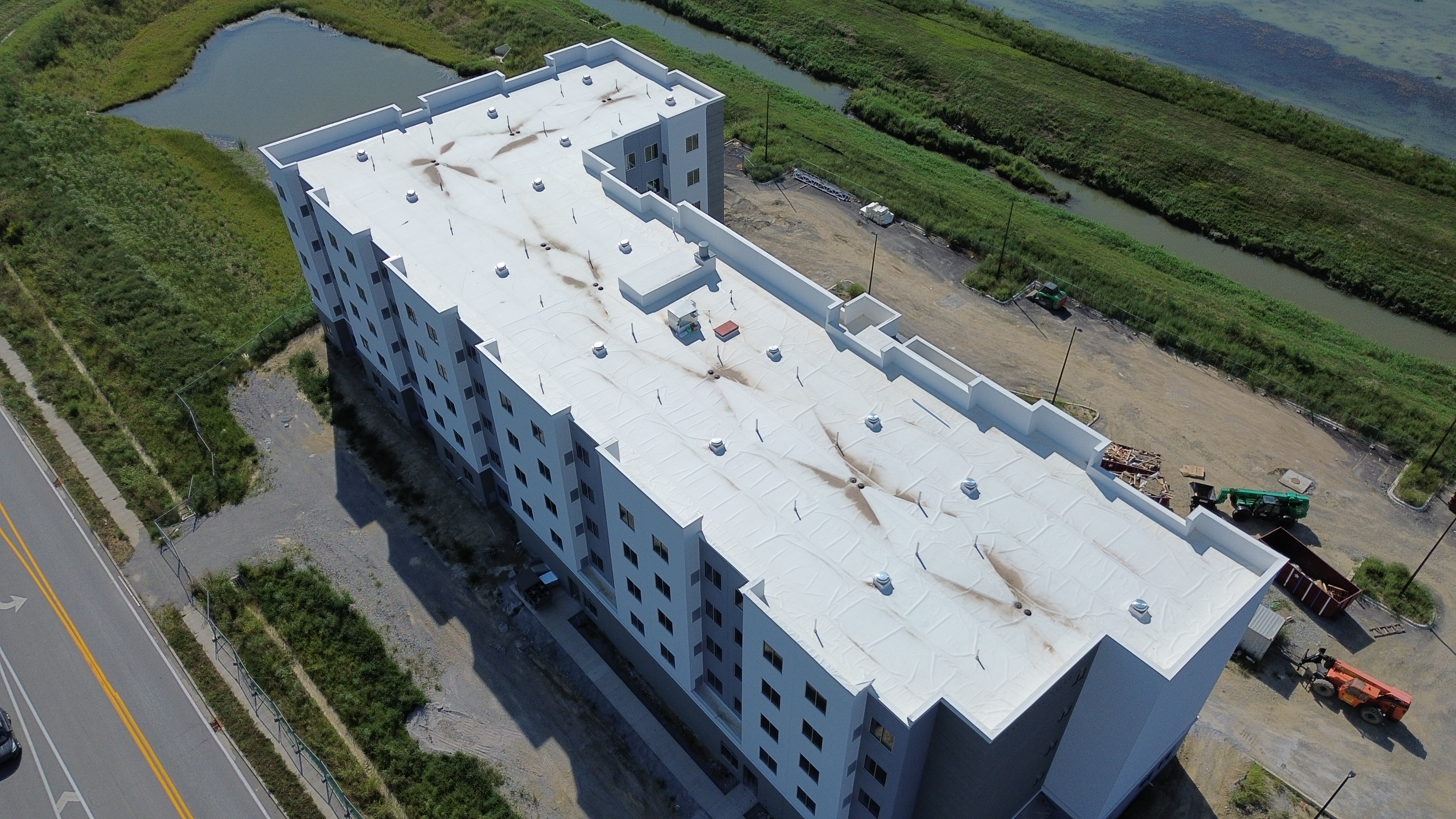Aerial view of a white TPO roof with parapet walls and rooftop equipment.