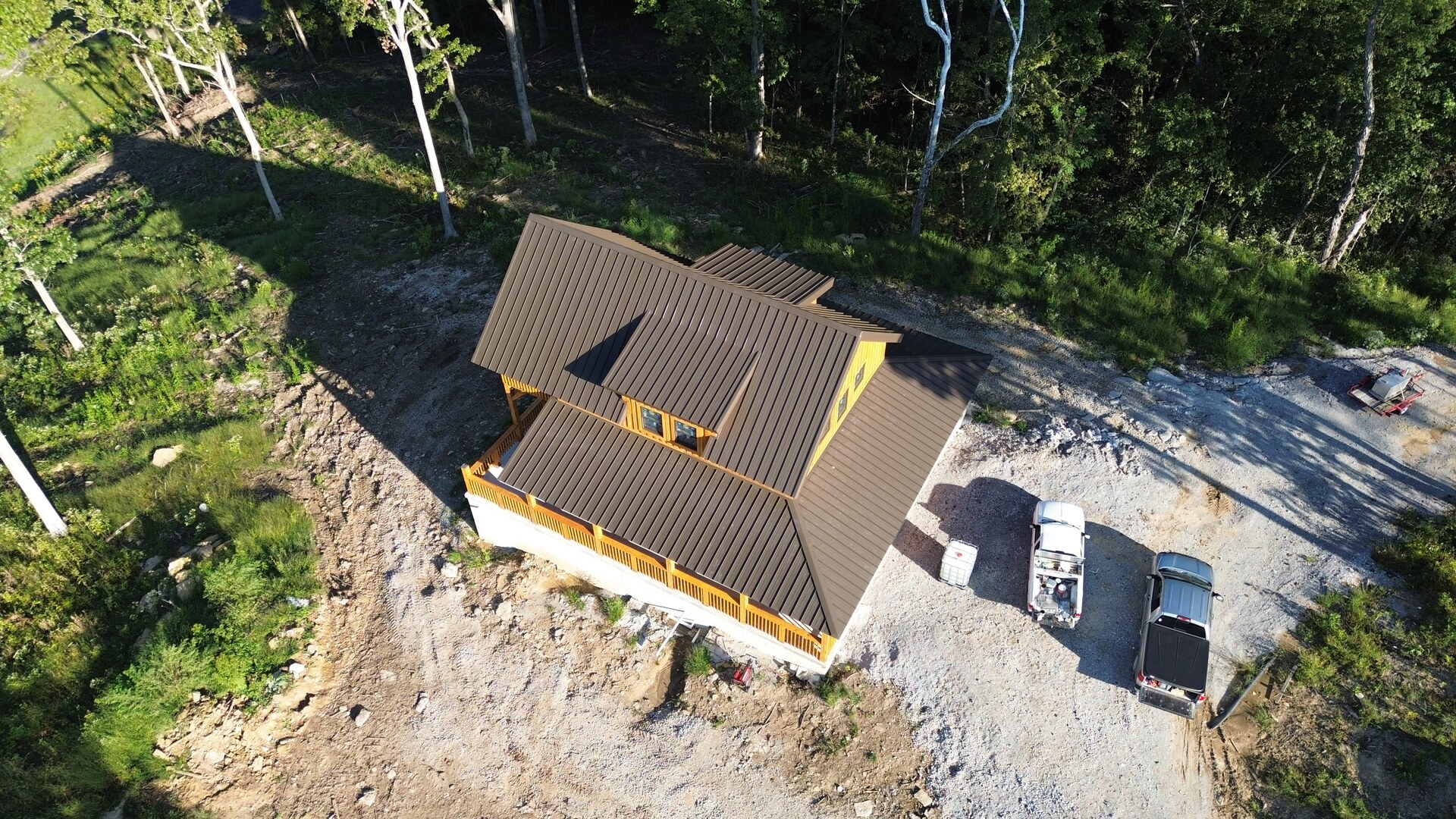 Aerial view of a cabin in Pleasureville, KY with a brown snap-lock metal roof installed by Innova