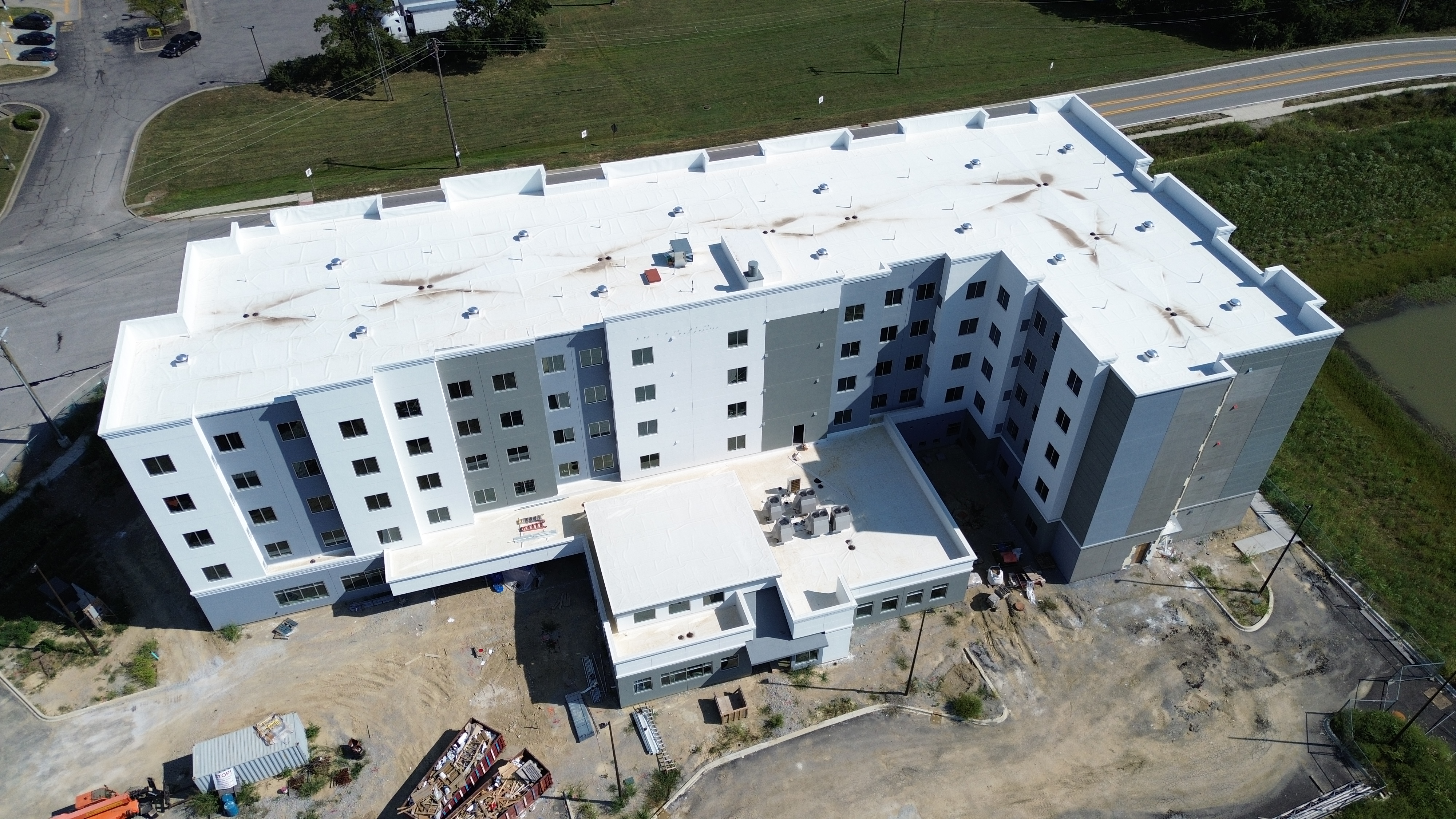 Aerial view of the completed Fairdale Hotel in Louisville, Kentucky, showing the white low-slope TPO roof across the four-story building.