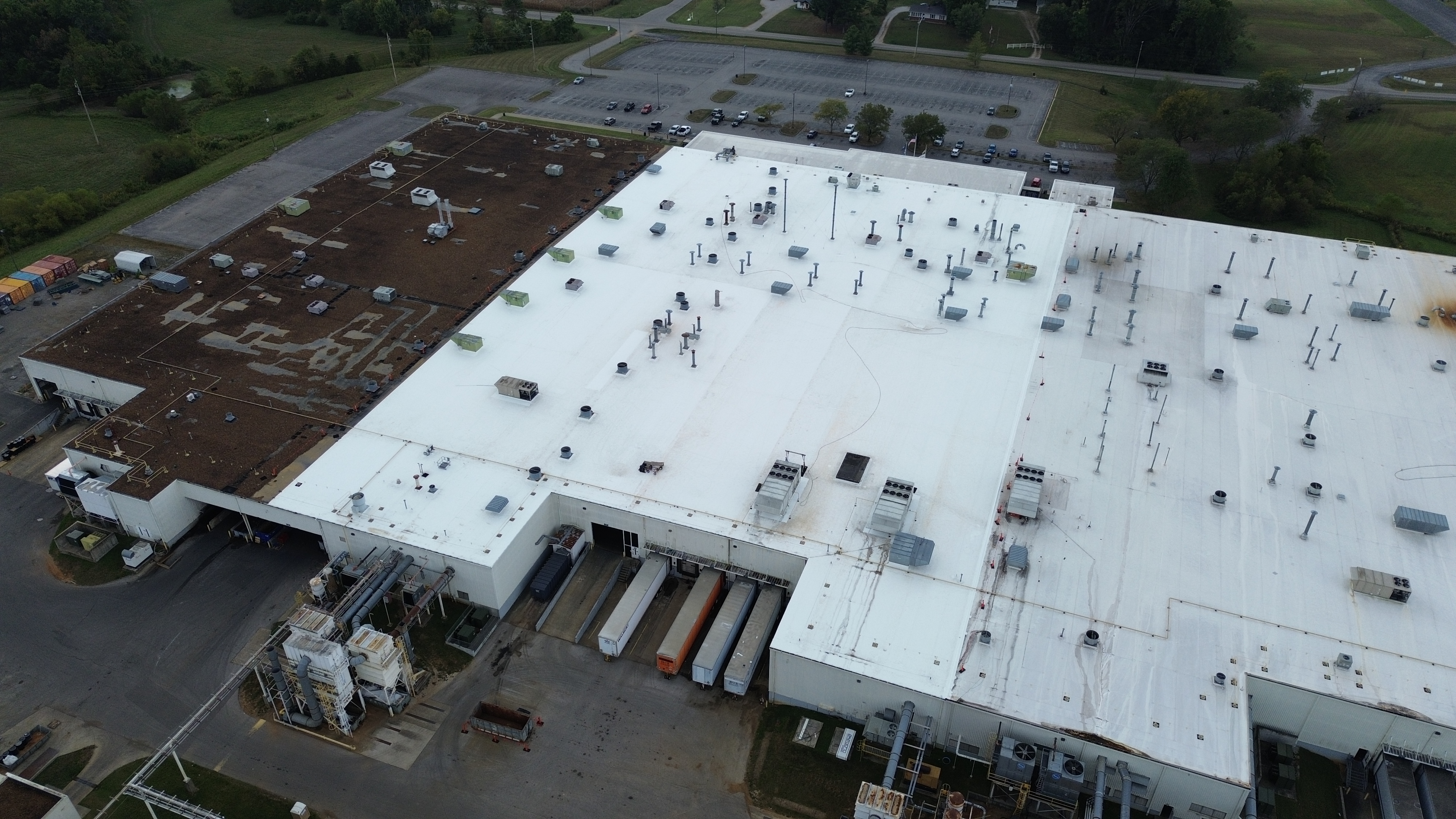 Aerial view of an industrial building's white roof and front loading docks.